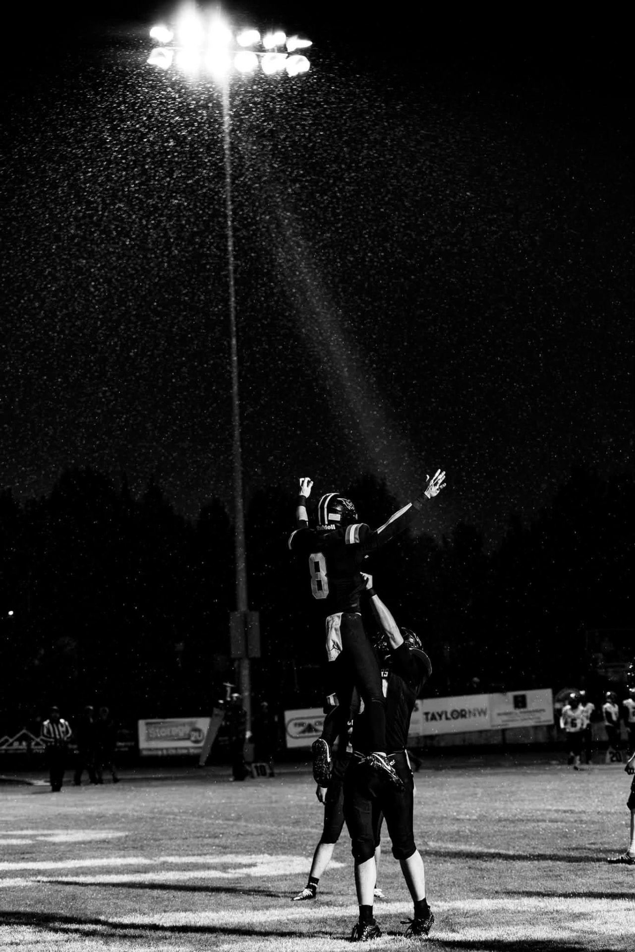 Cougars player celebrates under the stadium lights in the rain