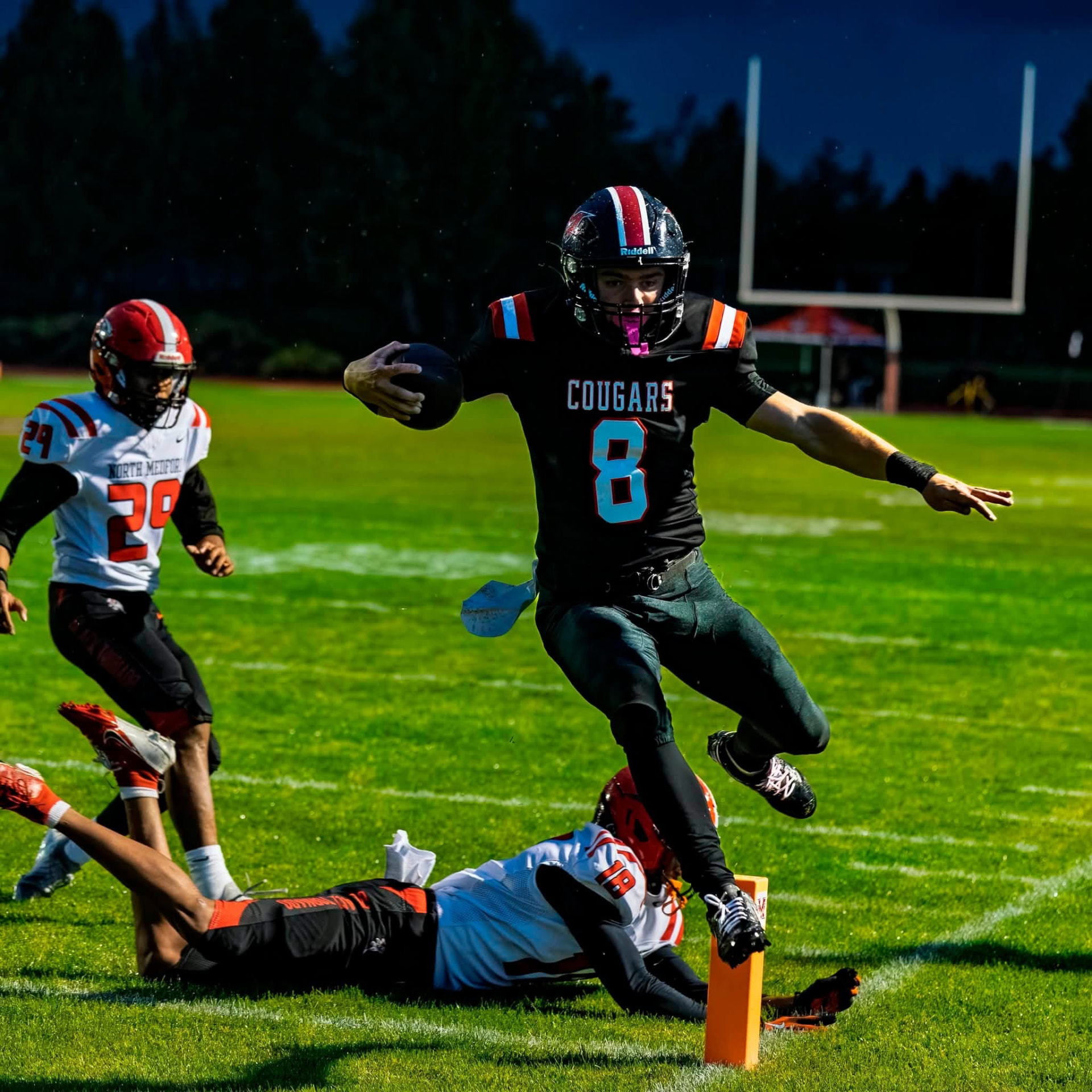 Cougars player leaps over a defender against North Medford